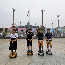 a group of people riding on scooters in a square