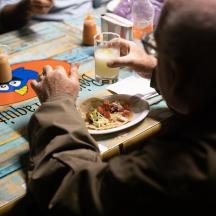 a group of people sitting at a table with a plate of food