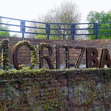 eine Backsteinmauer mit einem Schild mit der Aufschrift „Parks“
