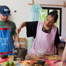 un homme et une femme debout dans une cuisine en train de préparer de la nourriture