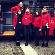 a group of people standing in front of a bus