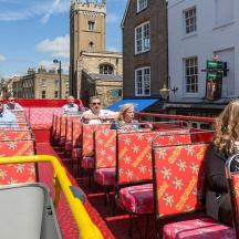 a group of people sitting on a tram in a city