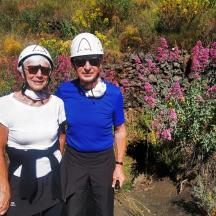 a man and woman standing in front of flowers
