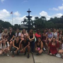 a group of people posing for a picture in front of a fountain