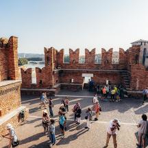 a group of people walking around a brick building