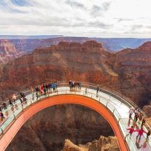 a group of people on a bridge over the grand canyon