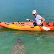 a woman in a kayak with a shark in the water