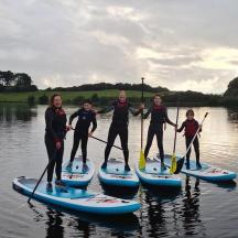 a group of people on paddle boards on the water