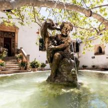 a statue of a woman sitting under a tree