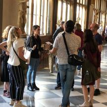 a group of people standing in a hall in a museum