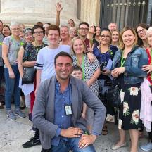 a group of people posing for a picture in front of a building