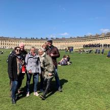 a group of people standing in the grass in front of a building