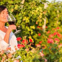eine Frau hält ein Glas Rotwein