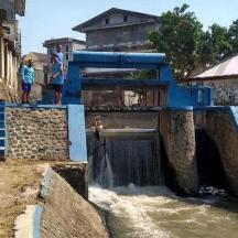 dues persones dempeus en un pont sobre una presa d'aigua