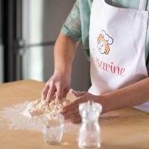 a woman in apron preparing food on a table