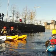 a group of people in kayaks in the water near a castle