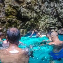 a group of people in the water in a cave