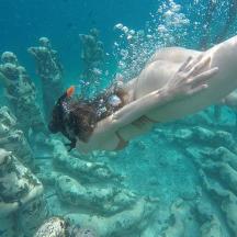a woman swimming in the ocean with a fish