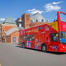 a red double decker bus driving down a street