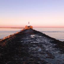 a lighthouse on the end of a pier in the water