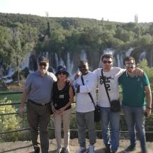 eine Gruppe von Menschen posiert für ein Foto vor einem Wasserfall