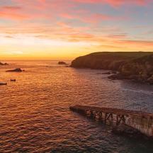 a sunset over a body of water with a pier