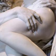a statue of a woman with her hands on her knee