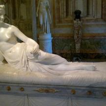 a statue of a woman sitting on a bed
