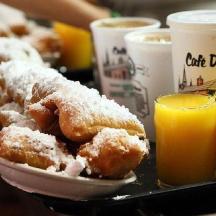 a tray with two plates of donuts and two glasses of orange juice