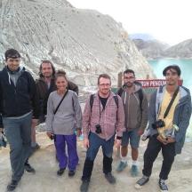 a group of people standing in front of a waterfall