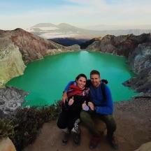 un home i una dona posant davant d'un llac verd