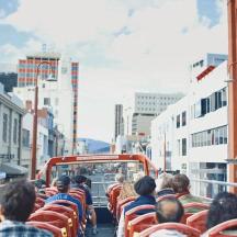 a group of people riding a bus down a city street
