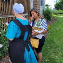 two women standing in a yard talking to each other