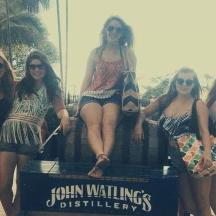a group of women sitting on a sign on the beach