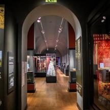 a hallway in a museum with a dress on display