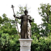 a statue of a man holding a stick and a cross