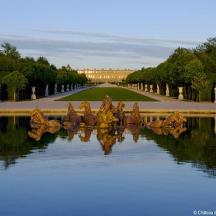a reflection of a fountain in the water in a park