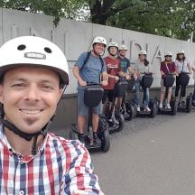 a man standing in front of a group of people riding on segways