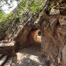 ein Eingang zu einer Steinmauer mit einem Steintunnel