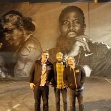 a group of people standing in front of a mural