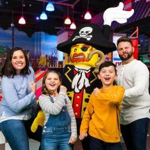 en familie poserer til et billede foran et piratkostume
