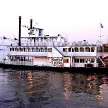 a ferry boat on the water with a bridge in the background