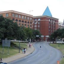 a street in front of a building with people walking down a road