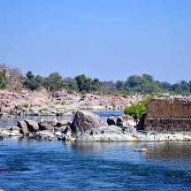 a river with some rocks and a castle in the background