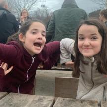 two young girls are posing for a picture at a table