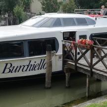 ein Boot mit Menschen, die auf einer Brücke stehen