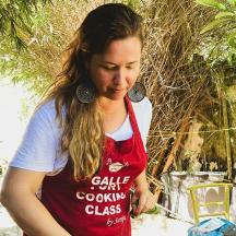 a woman in a red apron standing in a garden