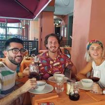 three people sitting at a table with wine glasses