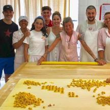a group of people standing in front of a large plank of food