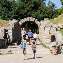 eine Gruppe von Menschen, die durch einen Steintunnel gehen